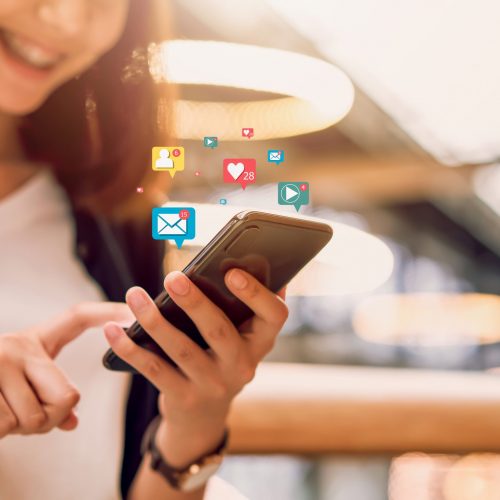 Social media and digital online concept, smiling Asian woman using smartphone and show technology icon.