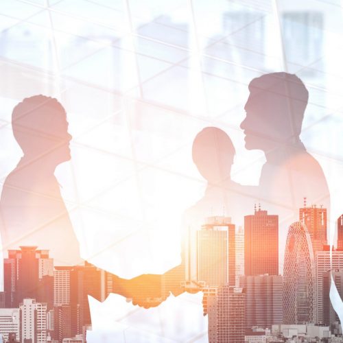 Double exposure image of many business people conference group meeting on city office building in background showing partnership success of business deal. Concept of teamwork, trust and agreement.